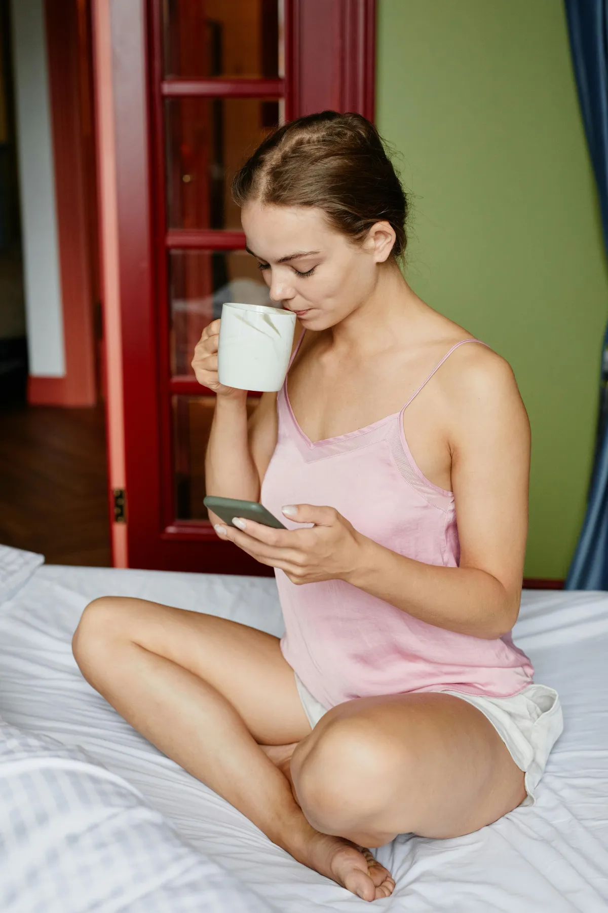 Couple in different locations both looking at phones with warm lighting