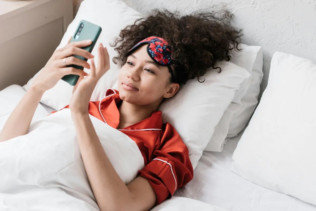 Person reading a shared journal entry on their phone with a soft smile, couple journaling benefits