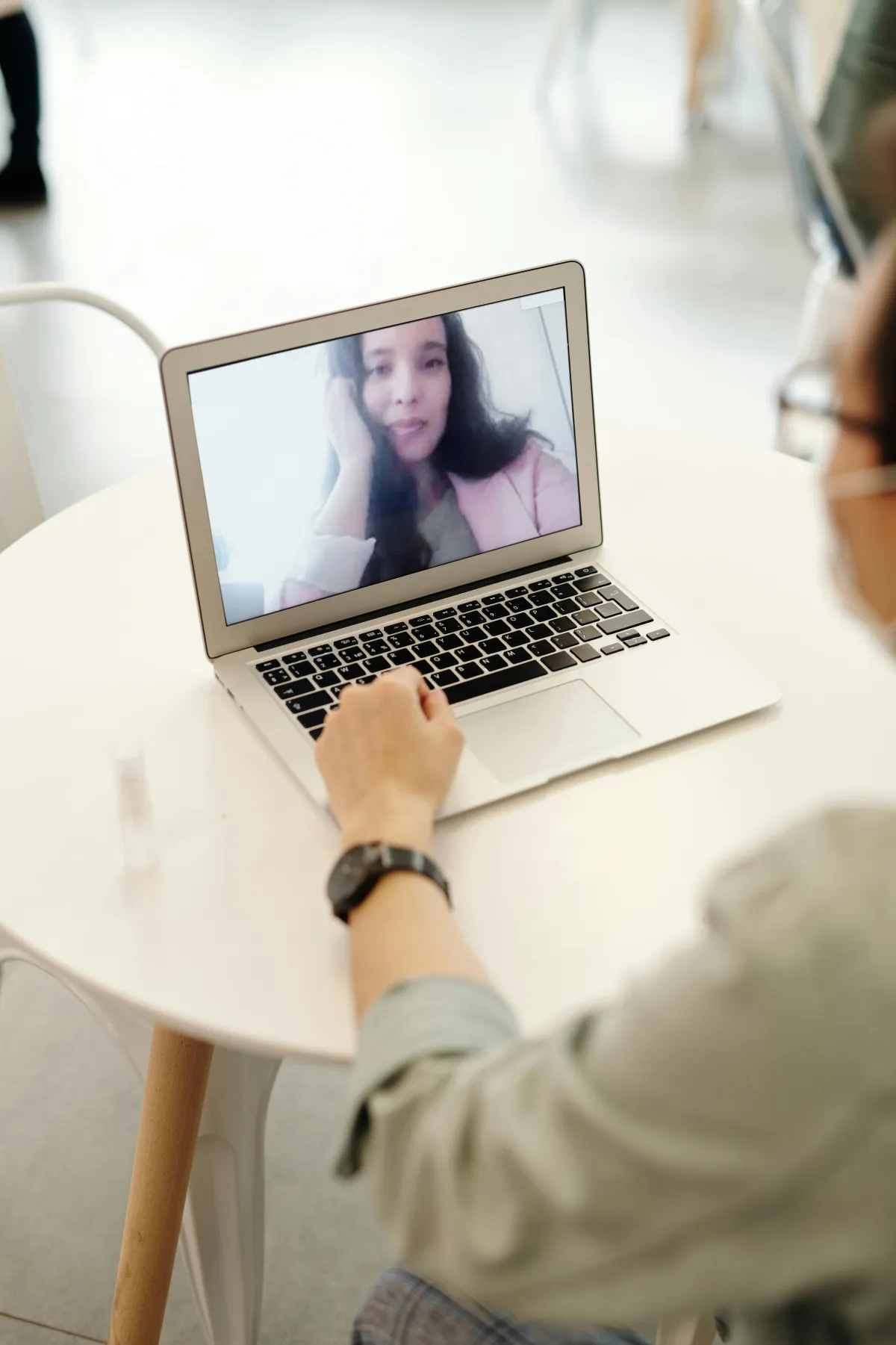 Two people video calling, smiling at each other on screen