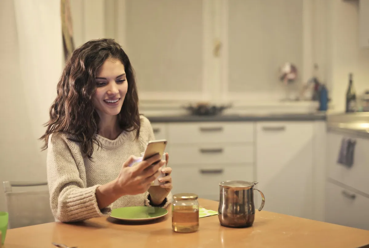 Person writing a single thought on their phone with a warm expression, one thought a day relationship
